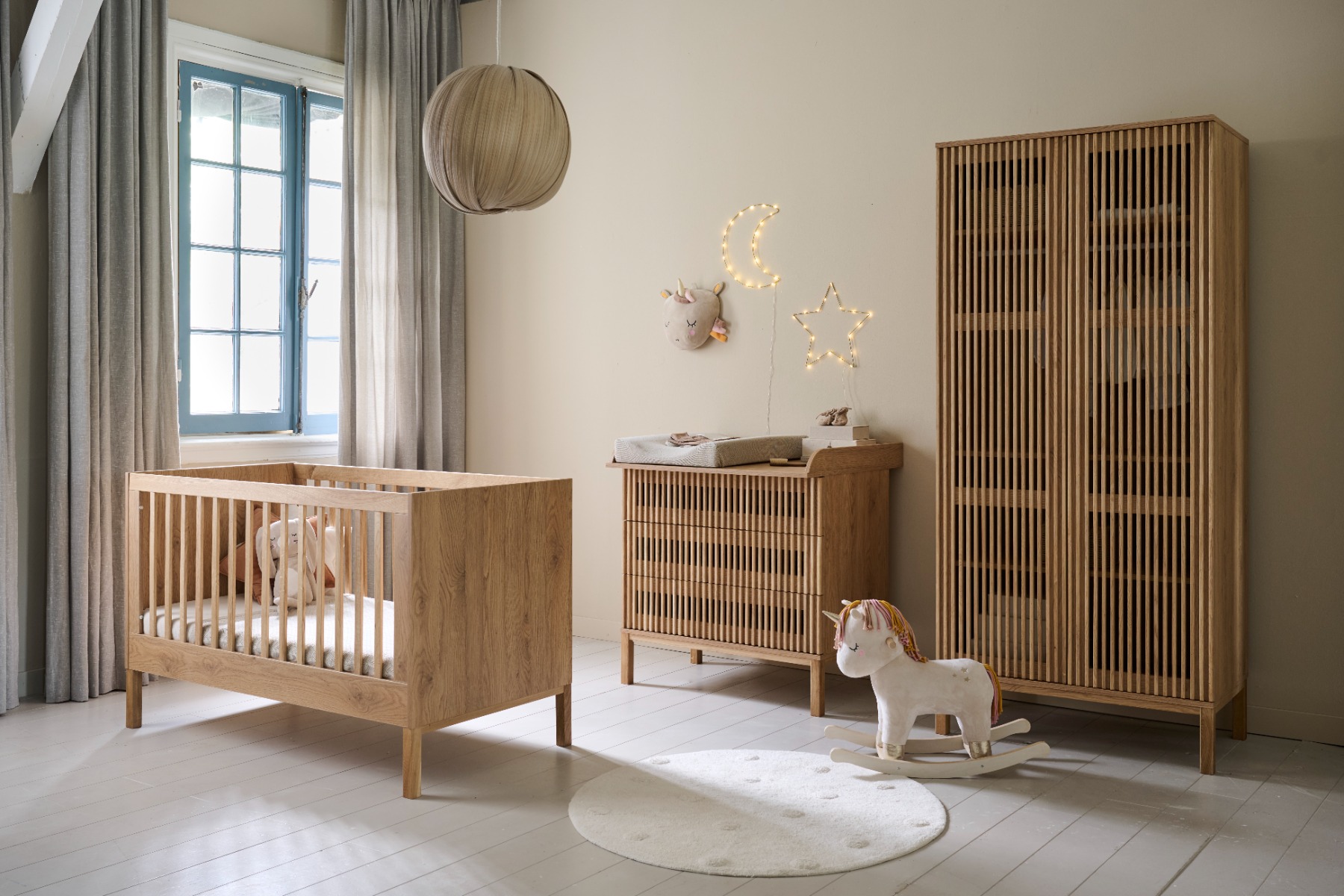 Complete babykamer in Japandi-stijl met bijpassend bedje, commode en grote kast.