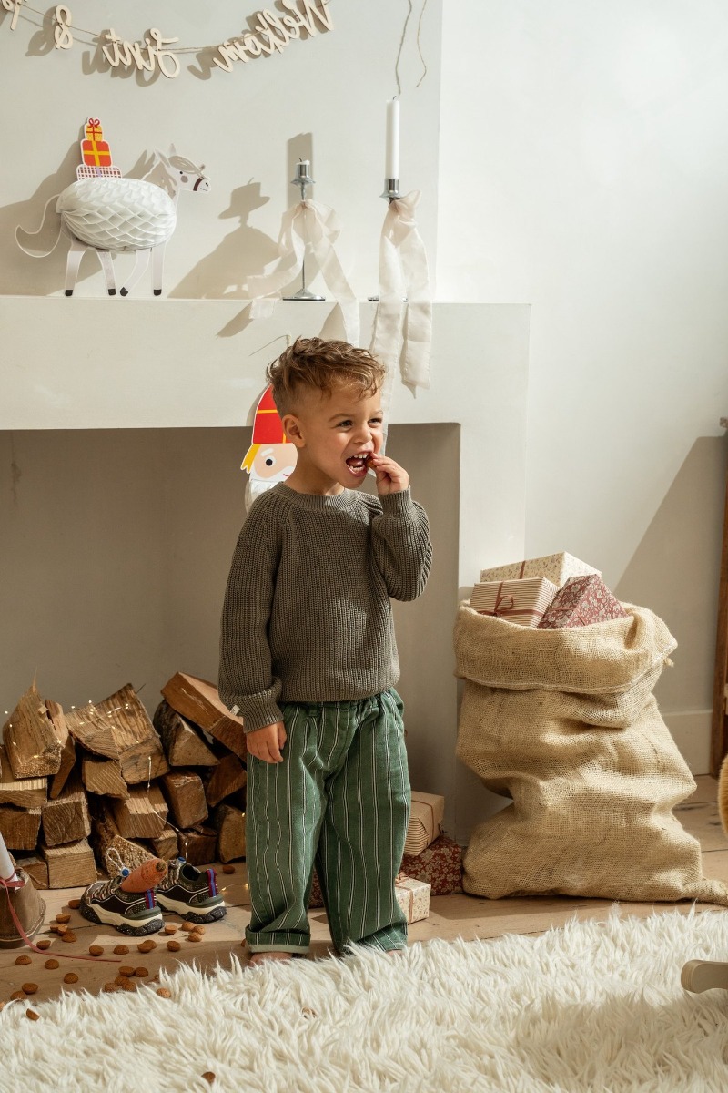 Jongen bij de schouw met de jutezak vol cadeaus